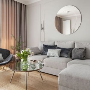 Fotel w salonie ustawiono przy wygodnej, trzyosobowej sofie zrobionej na zamówienie (Rafek Meble). Projekt: Studio Projektowania Miśkiewicz Design. Fot. Anna Powałowska