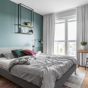 Zielona ściana za łóżkiem pomalowana farbą. Projekt Raca Architekci. Fot. Fotomohito 