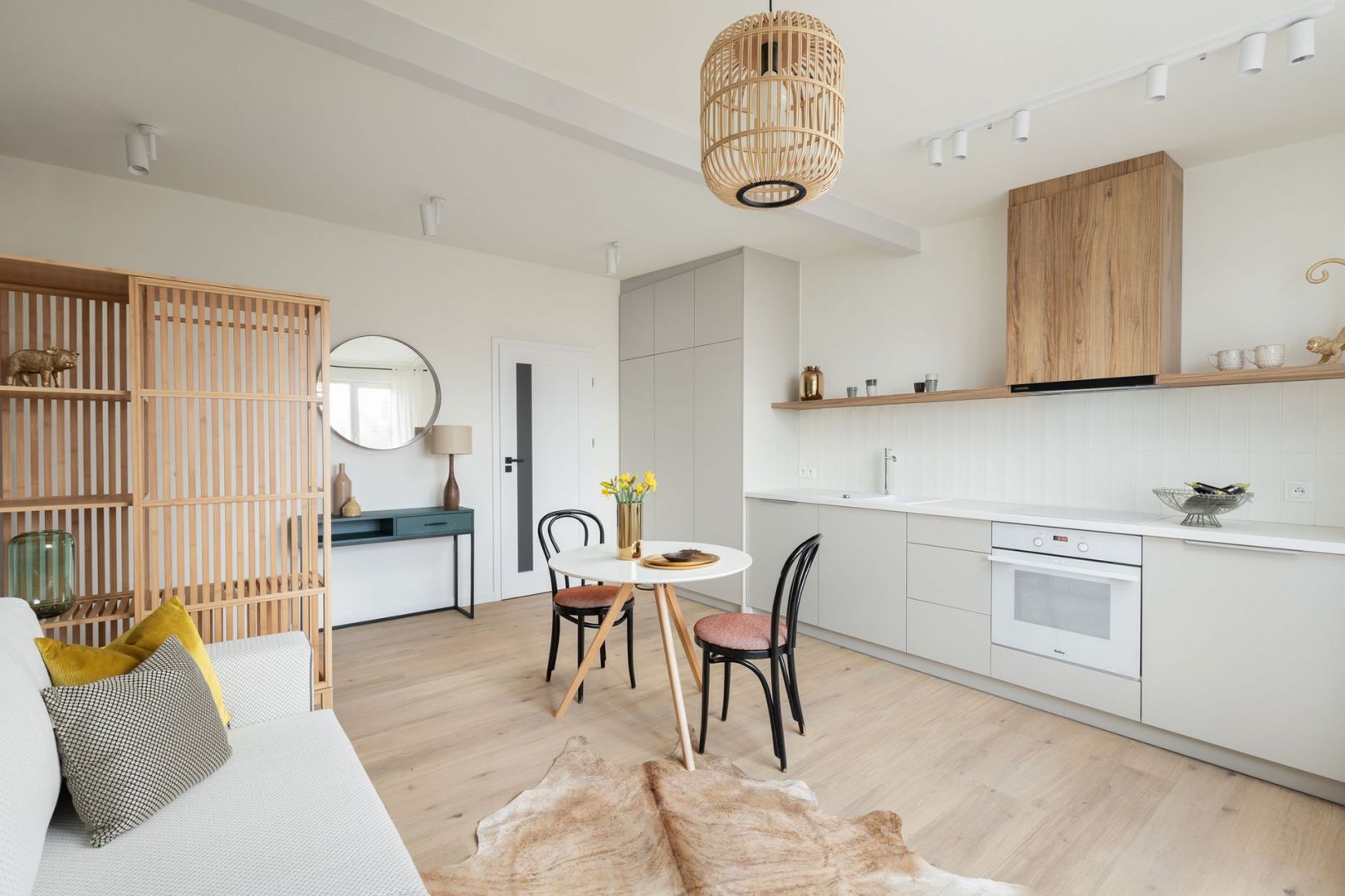 Otwarta część dzienna łączy strefę wypoczynkową, kuchnię i małą jadalnię. Projekt: Ola Dąbrówka, GOOD VIBES Interiors. Fot. Mikołaj Dąbrowski