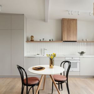 Ściana nad blatem w kuchni wykończona jest białymi płytkami. Idealnie pasują one do jasnych mebli oraz do drewnianych elementów. Projekt: Ola Dąbrówka, GOOD VIBES Interiors. Fot. Mikołaj Dąbrowski
