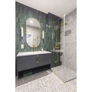 Małą łazienkę z prysznicem wykończono płytkami w kolorze butelkowej zieleni. Podłogę i ściany zdobią płyty z modnym motywem lastryko. Projekt: Decoroom Fot. Pion Poziom