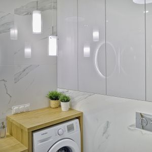 W łazience wygospodarowano miejsce na pralkę oraz na pojemne szafki. Projekt: Beata Ignasiak, pracownia Ignasiak Interiors. Fot. Grupa Deix