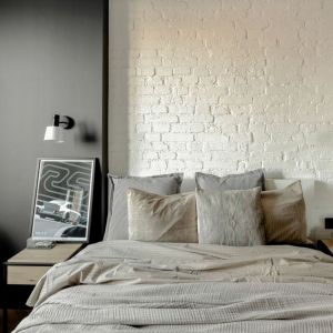 Ściana za łóżkiem w sypialni wykończona jest cegłą w białym kolorze. Projekt: Fuga Architektura. Fot. Aleksandra Dermont