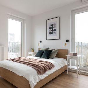 Ściana za łóżkiem w sypialni wykończona jest farbą w białym kolorze. Projekt i zdjęcia: KODO Projekty i Realizacje Wnętrz