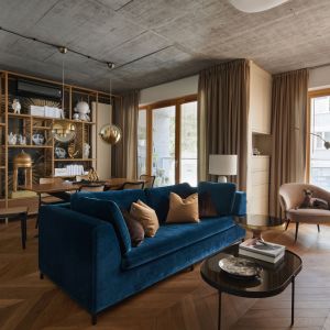 Niebieska kanapa i beżowy fotel świetnie wyglądają w stylowym salonie. Projekt: Karol Ciepliński, pracownia BLACKHAUS. Fot. Bartłomiej Sękowski