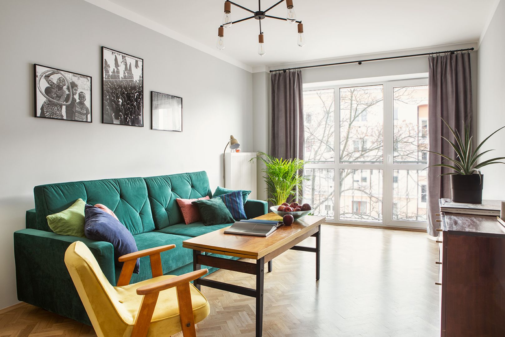 Sofa w kolorze butelkowej zieleni i żółty fotel pięknie ożywiają jasny salon. Projekt: Monika Skuza, CudnieBosko. Fot. Kamila Markiewicz-Lubańska. Stylizacja: Maria Szymańska