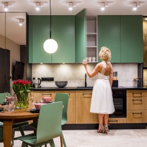 Górne szafki w kuchni mają soczyście zielone fronty. Projekt: Ewa Tarapata Architekt Wnętrz. Fot. Mateusz Gąska