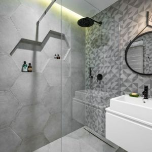 Charakteru małej łazience z prysznicem bez brodzika nadają geometryczne płytkami. Projekt: Zuzanna Kuc, ZU projektuje. Fot. Łukasz Zandecki