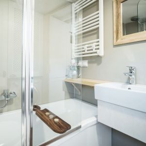 W łazience znalazła się wanna z prysznicem. Projekt wnętrz: pracownia Nasze Nowe. Realizacja domku: Tiny Smart House Polska