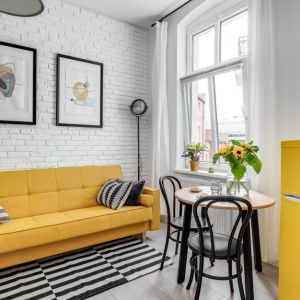 Jasny salon doskonale ożywia kolor żółty zastosowany w aranżacji. Projekt: Ewelina Matyjasik-Lewandowska. Fot. Piotr Wujtko