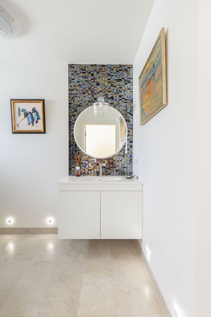 Ściany i podłogę w strefie mokrej zdobią płytki imitujące trawertyn, które ładnie łączą się z oryginalną, szklaną mozaiką barwioną w masie. Projekt: Katarzyna Rohde, Home&Style. Fot. PionPoziom