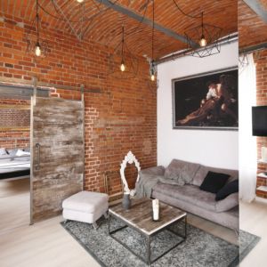 Ściany z cegły pięknie zdobią salon i sypialnię. Projekt: Nowa Papiernia. Fot. Bartosz Jarosz