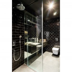 W łazience z prysznicem przeważa kolor czarny w połysku. Projekt: pracownia Magma. Fot. Fotomohito