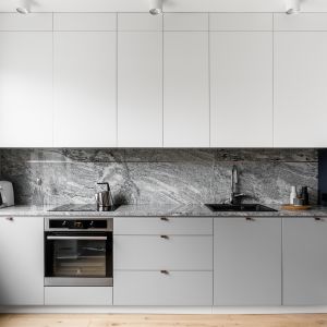 Biała nowoczesna kuchnia w minimalistycznym stylu. Projekt Raca Architekci. Fot. Fotomohito