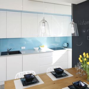 W białej kuchni postawiono na niebieskie szkło na ścianie nad blatem. Projekt Agnieszka Zaremba, Magdalena Kostrzewa-Świątek. Fot. Bartosz Jarosz