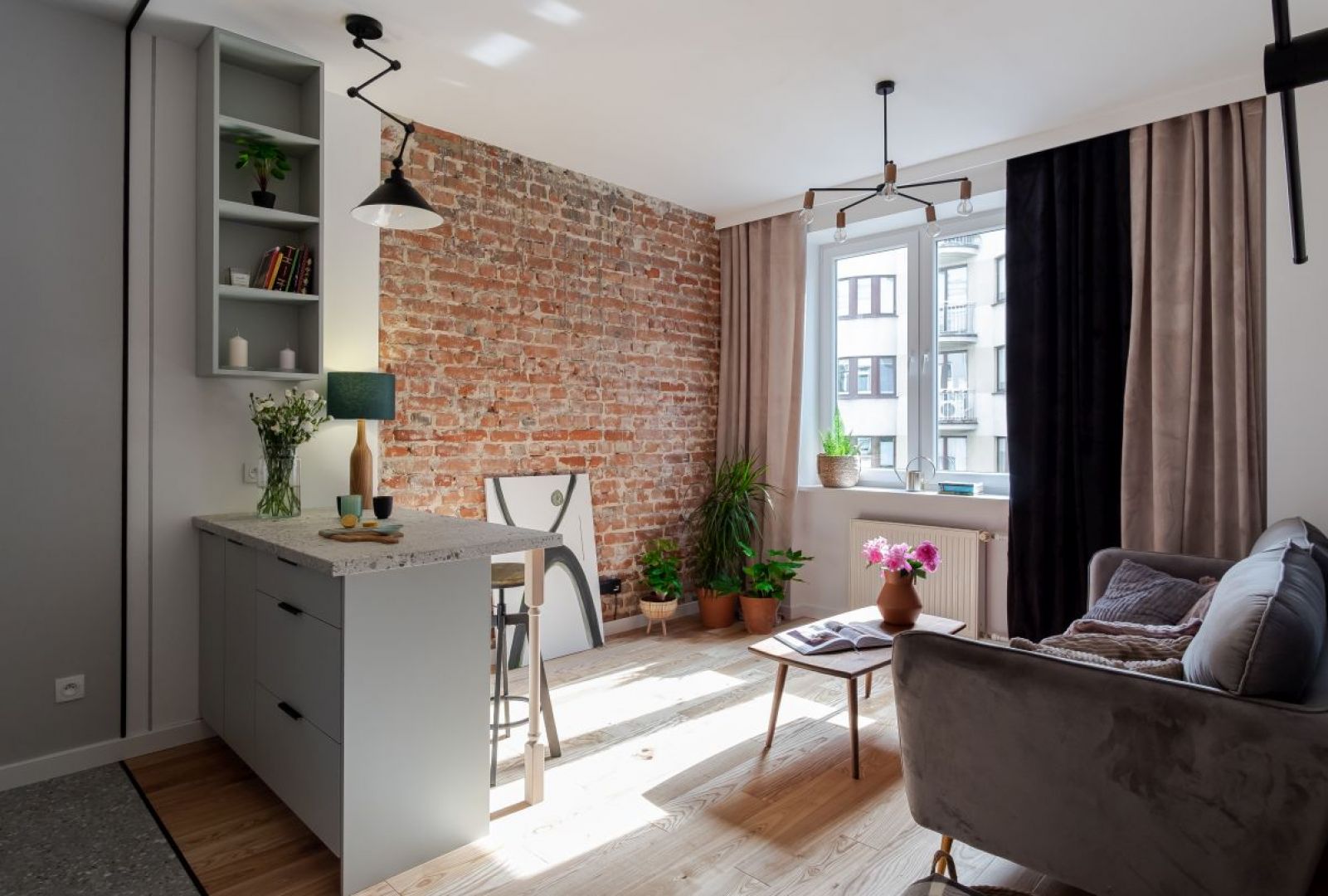 Na ścianie w salonie znajduje się oryginalna cegła, która nadaje wnętrzu klimatu. Projekt: Ewelina Latra-Kalinowska, Latre Design. Fot. Bernadetta Kuczyńska Interior Photography