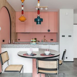 Kolor różowy stanowi bazę aranżacji kuchni połączonej z jadalnią. Dopełnia go biel. Róż inspirowany jest domem mody Acne Studios. Projekt i zdjęcie: KODO Projekty i Realizacje Wnętrz
