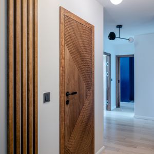 Detale wnetrza - lamele i piękne drewniane drzwi. Projekt wnętrz: Agata Komar, Versalka Studio. Fot: Wojciech Grodzki
