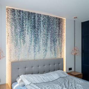 W sypialni na ścianie za łóżkiem znalazła się botaniczna tapeta. Projekt wnętrz: Agata Komar, Versalka Studio. Fot: Wojciech Grodzki
