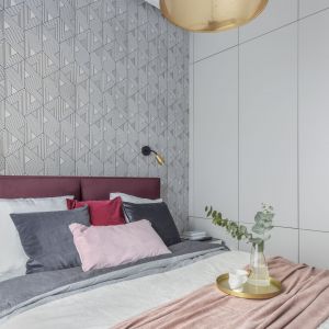 Pojemna, minimalistyczna szafa w kolorze białym idealnie wpisują się w aranżację sypialni. Projekt i zdjęcia: KODO Projekty i Realizacje Wnętrz