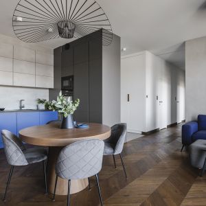 Niebieska sofa oraz fronty szafek w otwartej kuchni. Projekt: make Architekci. Zdjęcia: Hanna Połczyńska, Kroniki Studio