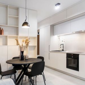 Mała kuchnia urządzona w białym kolorze z dużą ilością szafek. Projekt: Joanna Ochota. Zdjęcie: Maciej Sułek