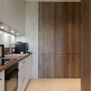Wysoka zabudowa kuchenna wykończona drewnem. Projekt i zdjęcia: KODO Projekty i Realizacje Wnętrz