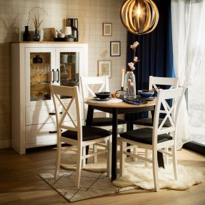 Do salonu w skandynawskim stylu pasuje okrągły drewniany stół i drewniane krzesła. Fot. Salony Agata