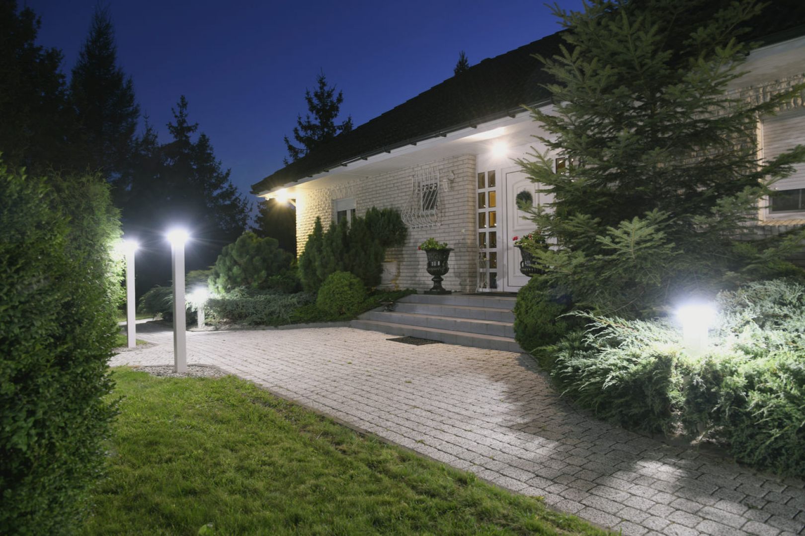 Wygodny dom o klasycznej formie z dużym, pięknie i praktycznie oświetlonym ogrodem. Fot. Plast-Met Systemy Ogrodzeniowe