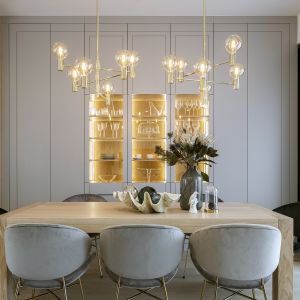 W jadalni pięknie prezentują się złote lampy nad stołem i podświetlane witryny w tej samej tonacji. Projekt: Monika i Adam Bronikowscy, Hola Design. Zdjęcia: Yassen Hristov