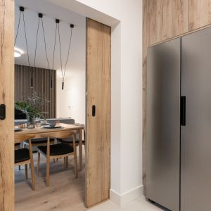 Przesuwne drzwi pozwalają oddzielić kuchnię od strefy od salonu i jadalni. Projekt i zdjęcia: KODO Projekty i Realizacje Wnętrz