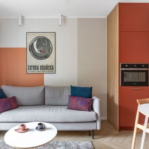 Ścianę za kanapą w salonie zdobi ciepła kolorystyka. Projekt: autorska pracownia Vzorovo. Zdjęcie: Natalia Kaczmarek, Inkadr