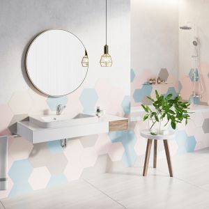 W pastelowej aranżacji łazienki heksagony asymetrycznie ułożono na ścianach i obudowie wanny. Fot. Ferro