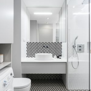 Łazienka z prysznicem w białym kolorze, której charteru dodają czarne dodatki. Projekt: Anna Maria Sokołowska. Zdjęcie: FotoMohito