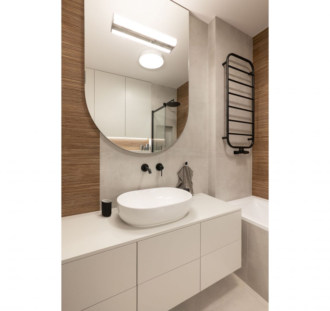 Mała łazienka w jasnych kolorach i z dużym lustrem. Projekt i zdjęcie: KODO Projekty i Realizacje Wnętrz