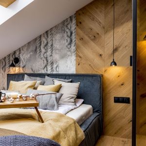 Ścianę za łóżkiem w sypialni zdobi tapeta od WonderWall studio oraz drewno ułożone w jodełkę. Projekt: Ewa Tarapata Architekt Wnętrz. Zdjęcie: Mateusz Gąska