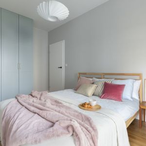 Ściana za łóżkiem w sypialni wykończona jest farbą w jasnym, szarym kolorze. Projekt: Joanna Węgłowska, pracowania Decoroom. Zdjęcie i stylizacja: Marta Behling, Pion Poziom – fotografia wnętrz