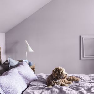 Liliowa ściana w minimalistycznej sypialni. Fot. mat. prasowe Tikkurila