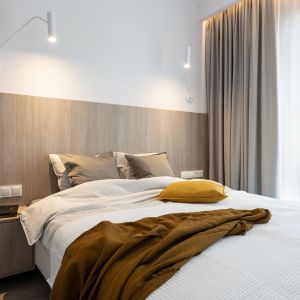 Drewno na ścianie za łóżkiem dodaje sypialni przytulności. Projekt i zdjęcia: KODO Projekty i Realizacje Wnętrz