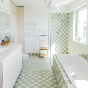 Zielona mozaika ułożona w przestrzeniach łazienki. Projekt: Atelier Starzak Strebicki. Zdjęcia: Mateusz Bieniaszczyk