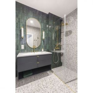 Małą łazienkę z prysznicem bez brodzika wykończono płytkami w kolorze butelkowej zieleni. Podłogę i ściany zdobią płyty z modnym motywem lastryko. Projekt: Decoroom Fot. Pion Poziom