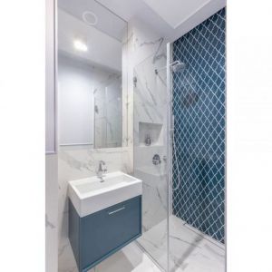 Małą, nowoczesną łazienkę z prysznicem bez brodzika ożywia ułożona pod prysznicem mozaika Raw Decor Shield Ocean Granate. Projekt: Decoroom. Fot. Pion Poziom