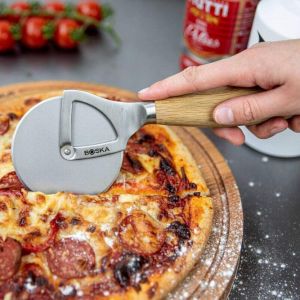 Nóż do pizzy Wheel Osło+.  Ma formę radełka. Został pokryty specjalną powłoką, dzięki której pizza nie klei się do jego powierzchni. Ma także poręczny, drewniany uchwyt. Cena: 84,90. Sprzedaż: Fabryka Form
