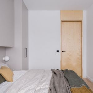 Zabudowa tworzy tło dla łóżka i w całości służy przechowywaniu, a niskie szuflady przy łóżku spełniają rolę szafek nocnych. Projekt: 3XEL Architekci. Zdjęcia: Dariusz Jarząbek 