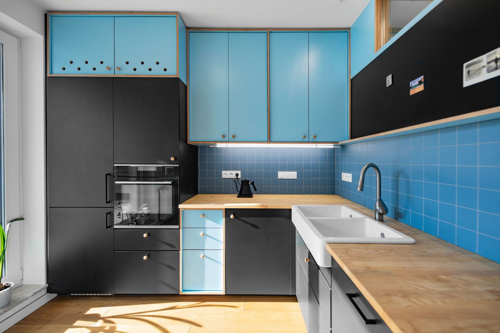 W kuchni dominuje kolor niebieski, który ładnie ożywia wnętrze. Projekt: Atelier Starzak Strebicki. Fot. Jakub Wittchen