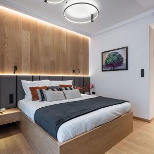 Ścianę za łóżkiem w sypialni pięknie zdobi naturalny forniru dębowy. Projekt i zdjęcie: KODO Projekty i Realizacje Wnętrz