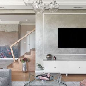Ściana za telewizorem w salonie wykończona jest tynkiem imitującym beton. Projekt Ewelina Rutkowska, studio projektowe Meteor. Fot. Tom Kurek.
