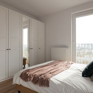 W sypialni znajduje się biała, pojemna szafa z lustrem. Projekt i zdjęcie: KODO Projekty i Realizacje Wnętrz