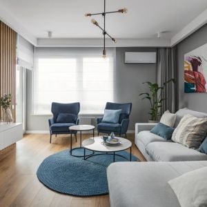 Niebieskie fotele w przytulnym, nowoczesnym salonie. Projekt wnętrza: Klaudia Tworo. Fot. Kamila Markiewicz-Lubańska