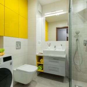 Łazienkę ożywia zabudowa meblowa z frontami w żółtym kolorze. Projekt: Justyna Mojżyk. Fot. Monika Filipiuk-Obałek